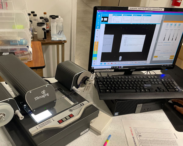 Imaging work station featuring a desktop computer, documents and a new ST Imaging microfiche scanner